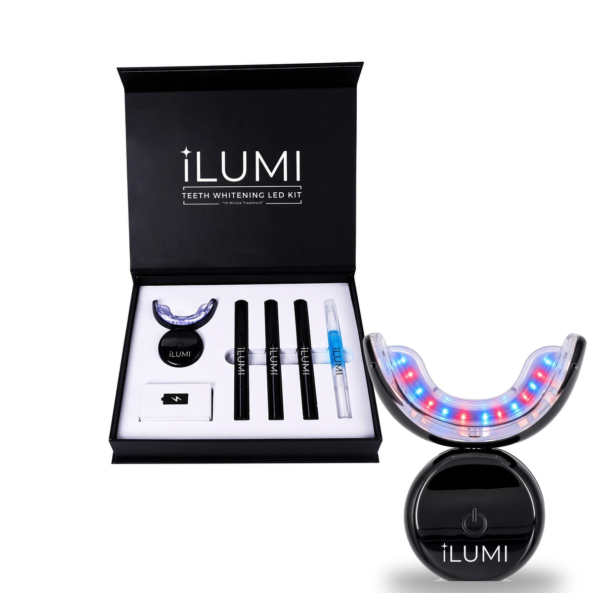 The open ILUMI LED Teeth Whitening Kit with its pens, shade guide and charging cable, with the lit red and blue LED device in front